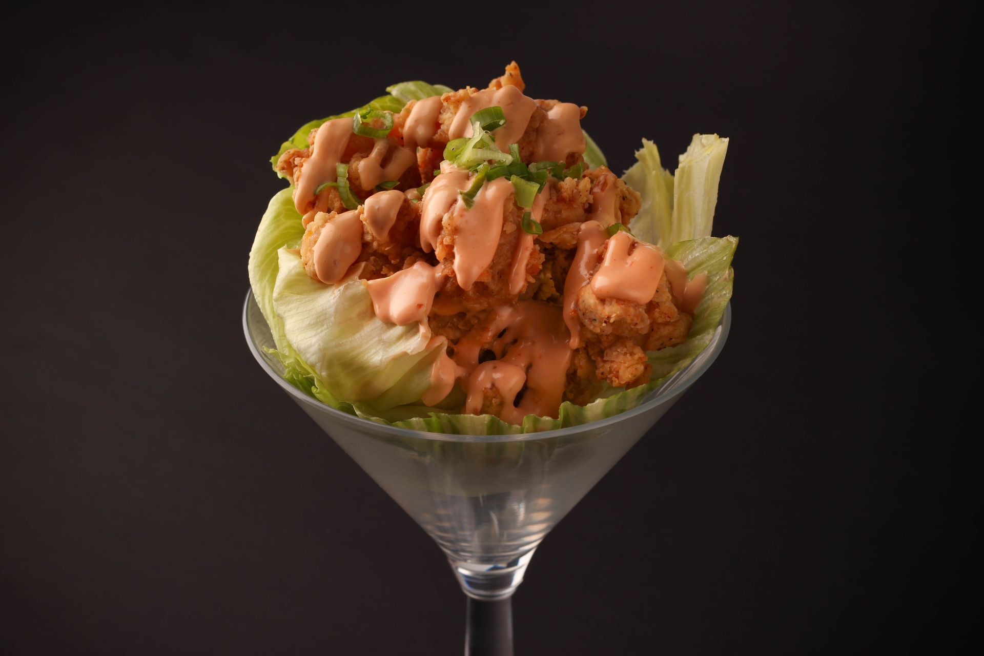 Sushi Restaurant | Finding Sushi | Salmon salad in a martini glass, topped with herbs on a dark background
