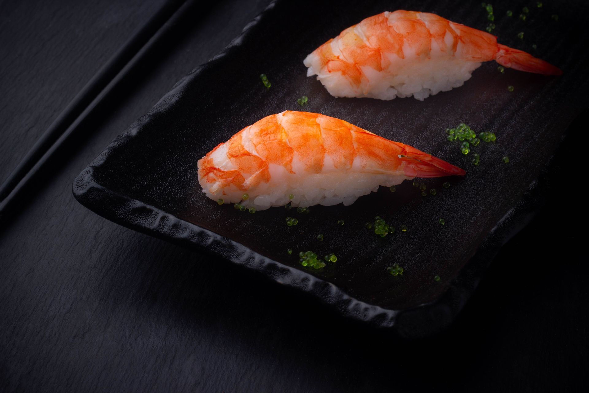 Sushi Restaurant | Finding Sushi | Two pieces of salmon nigiri on a black slate plate