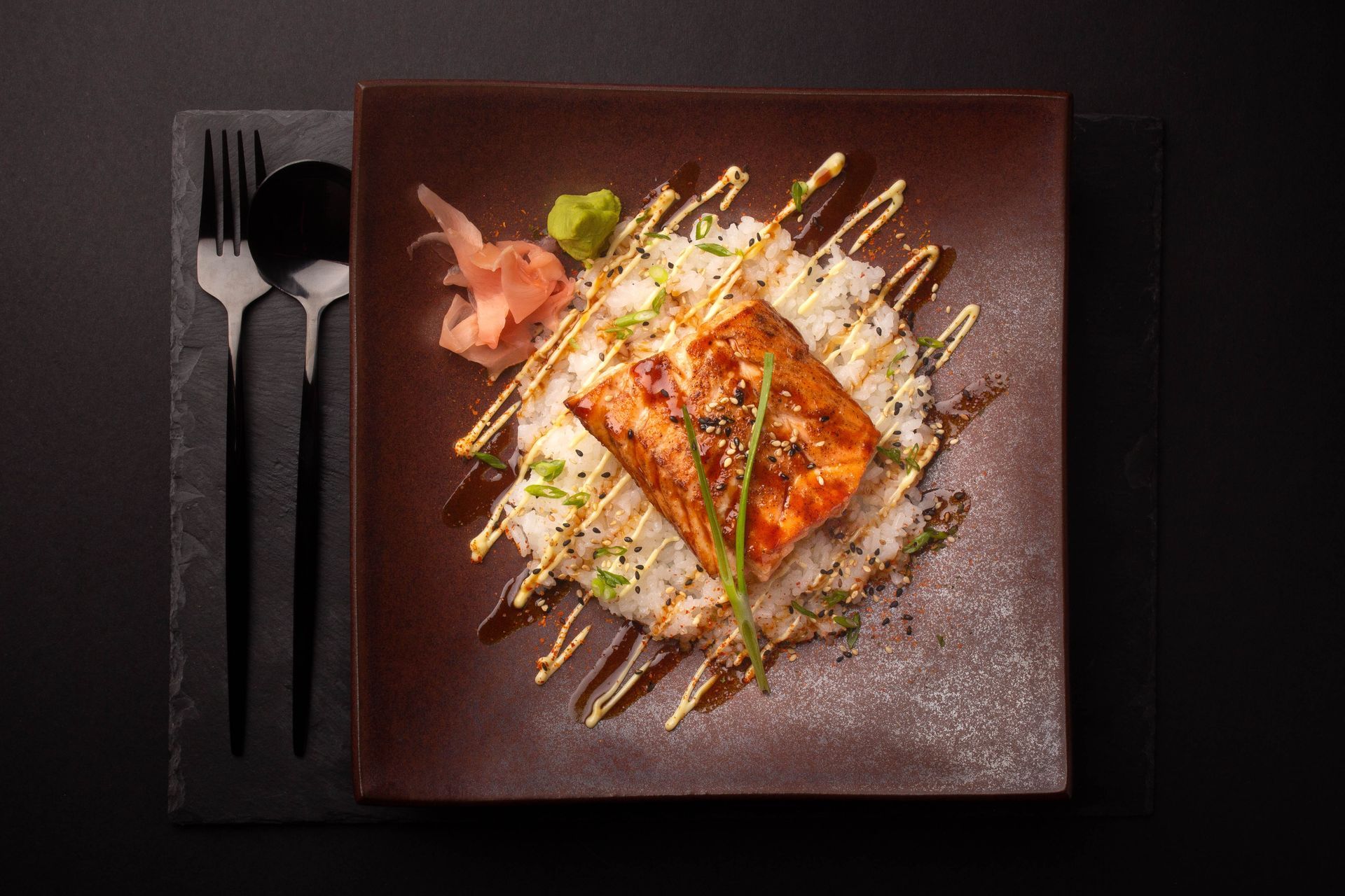 Sushi Restaurant | Finding Sushi | Gourmet plated salmon with sauce drizzle on a dark square plate