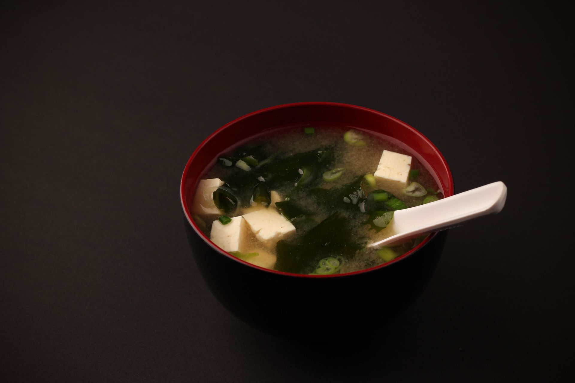 Sushi Restaurant | Finding Sushi | A bowl of miso soup with tofu and greens, topped 