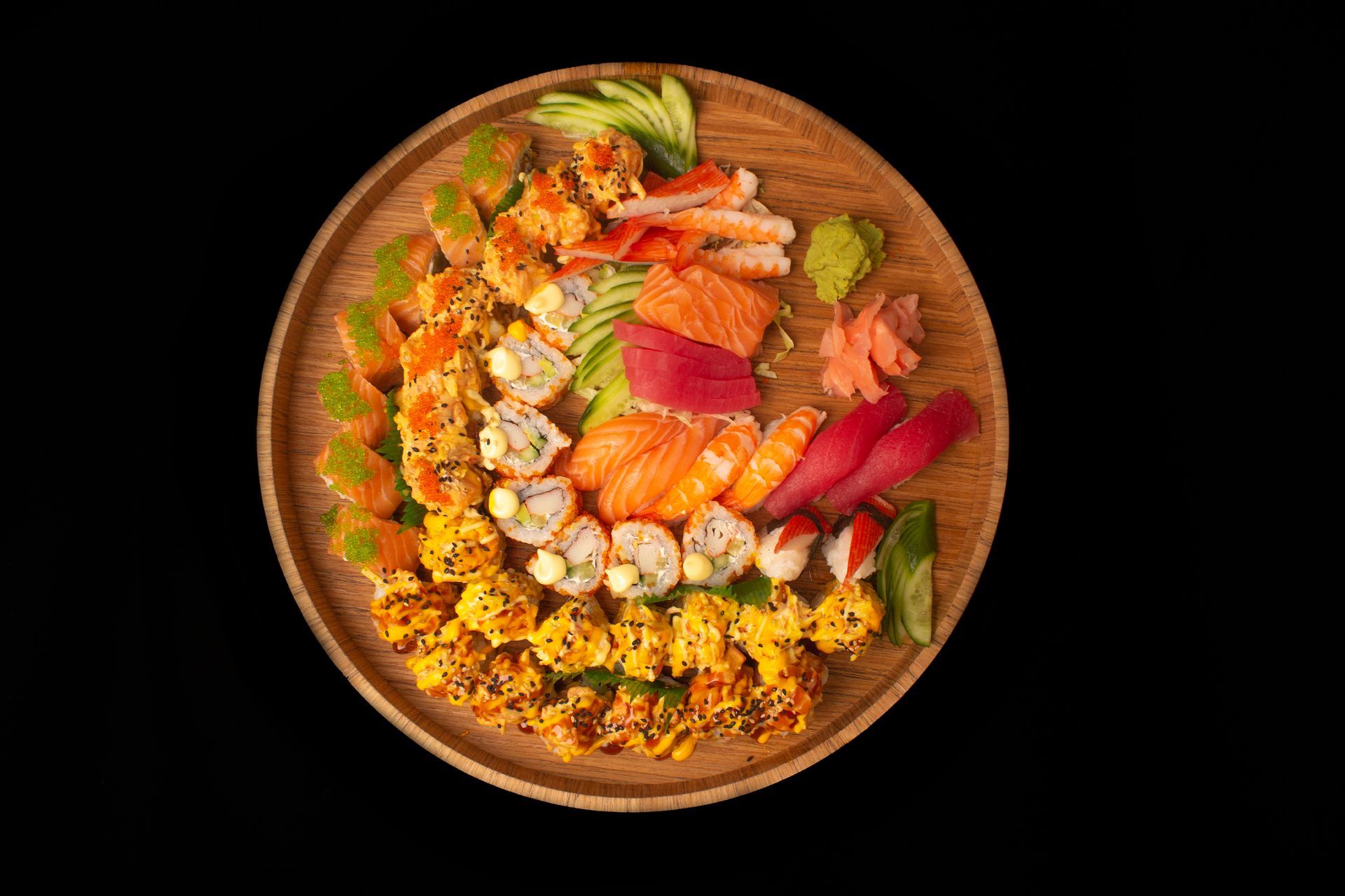 Sushi Restaurant | Finding Sushi | Sushi platter with assorted rolls and sashimi on a wooden plate, garnished 