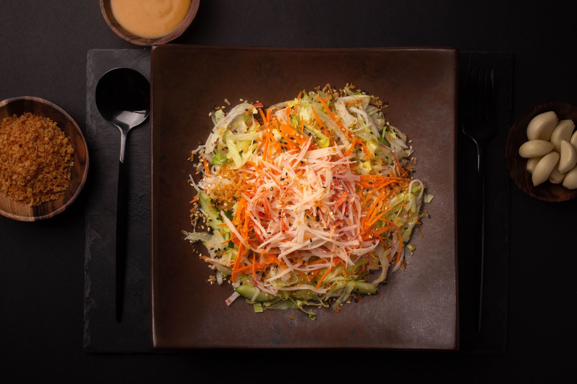Sushi Restaurant | Finding Sushi | Asian noodle bowl topped with shredded vegetables, served on a dark square plate 