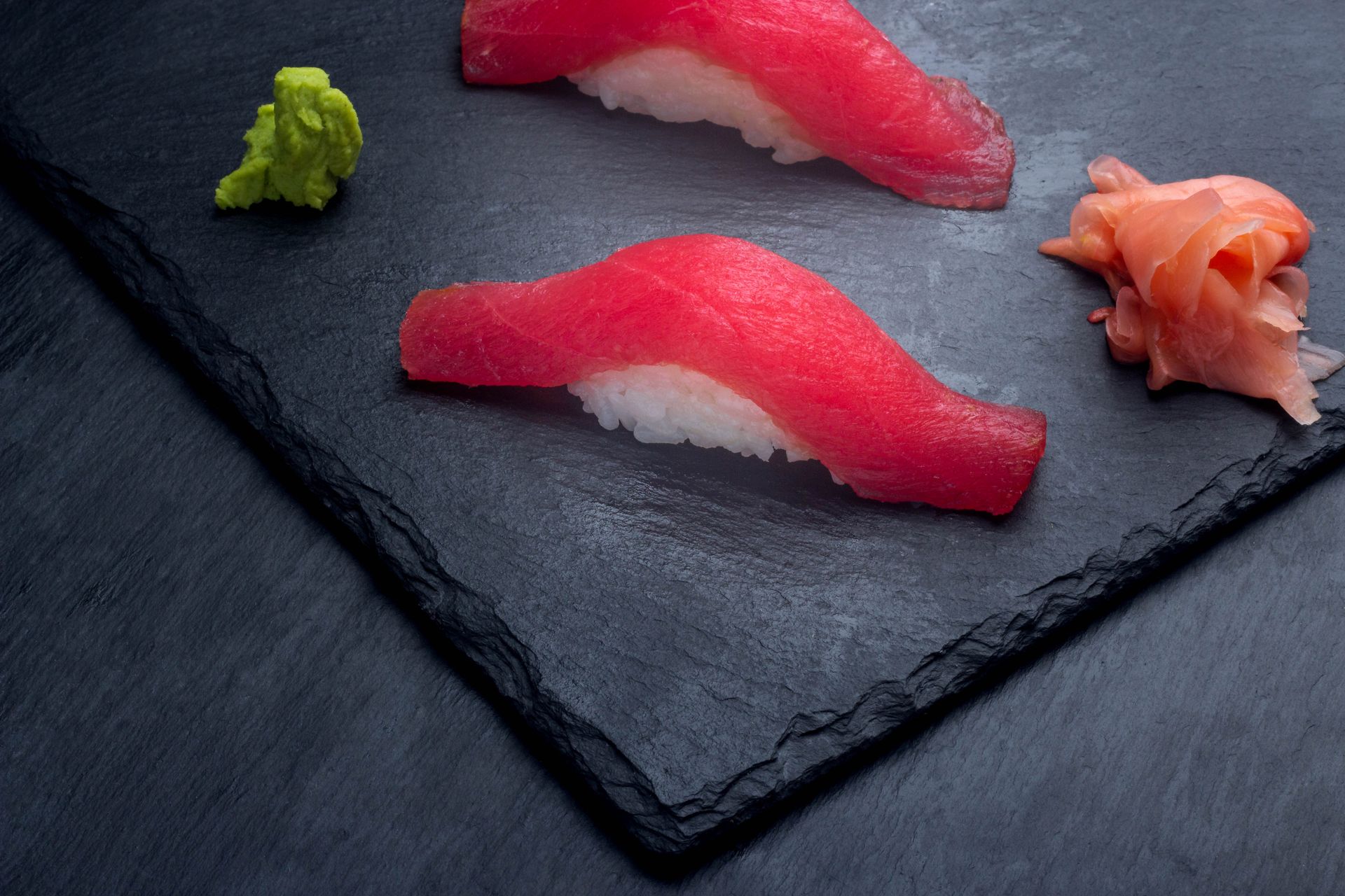 Sushi Restaurant | Finding Sushi |Sushi nigiri on a dark slate plate with wasabi and pickled ginger