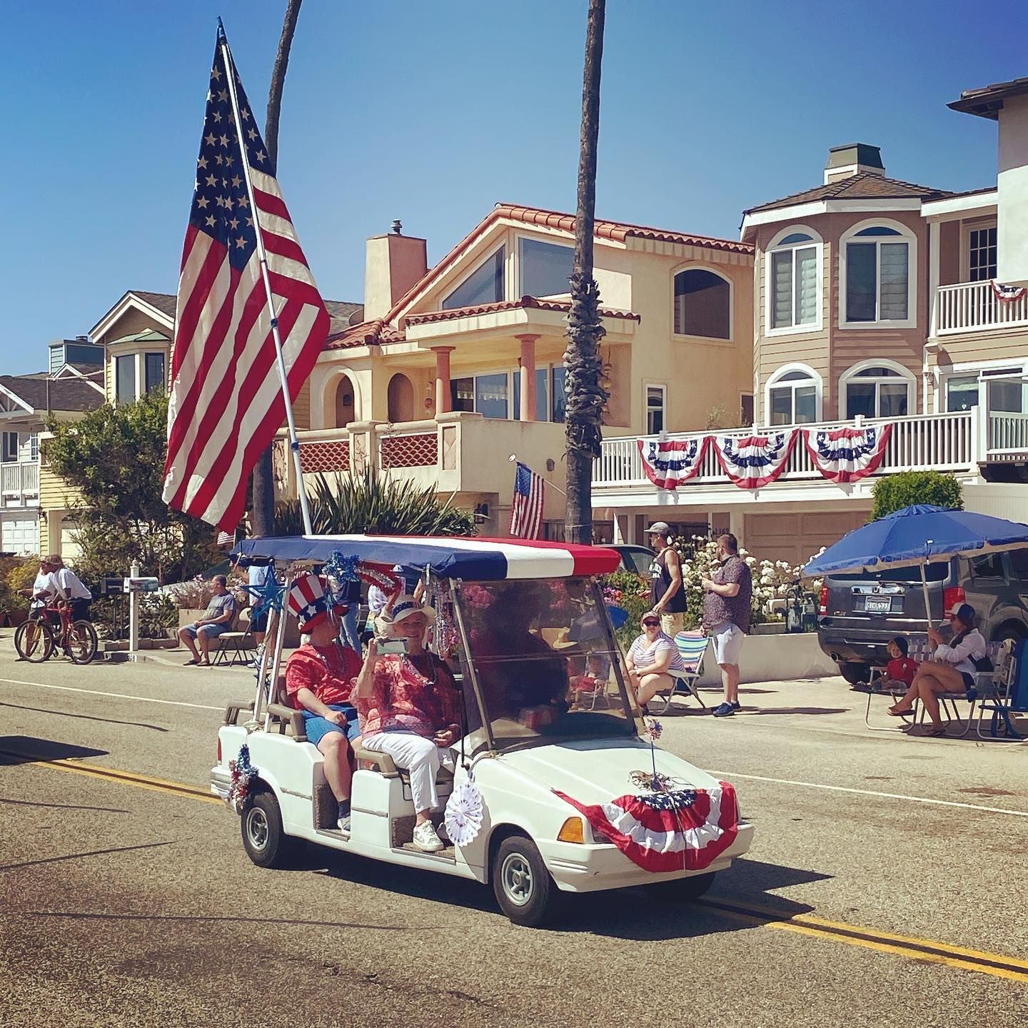 A golf cart is decorated for the 4th of july parade