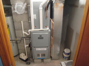 A room with a furnace and a water heater in it.