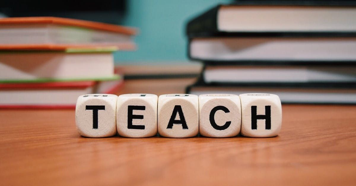 The word teach is spelled out on a wooden table
