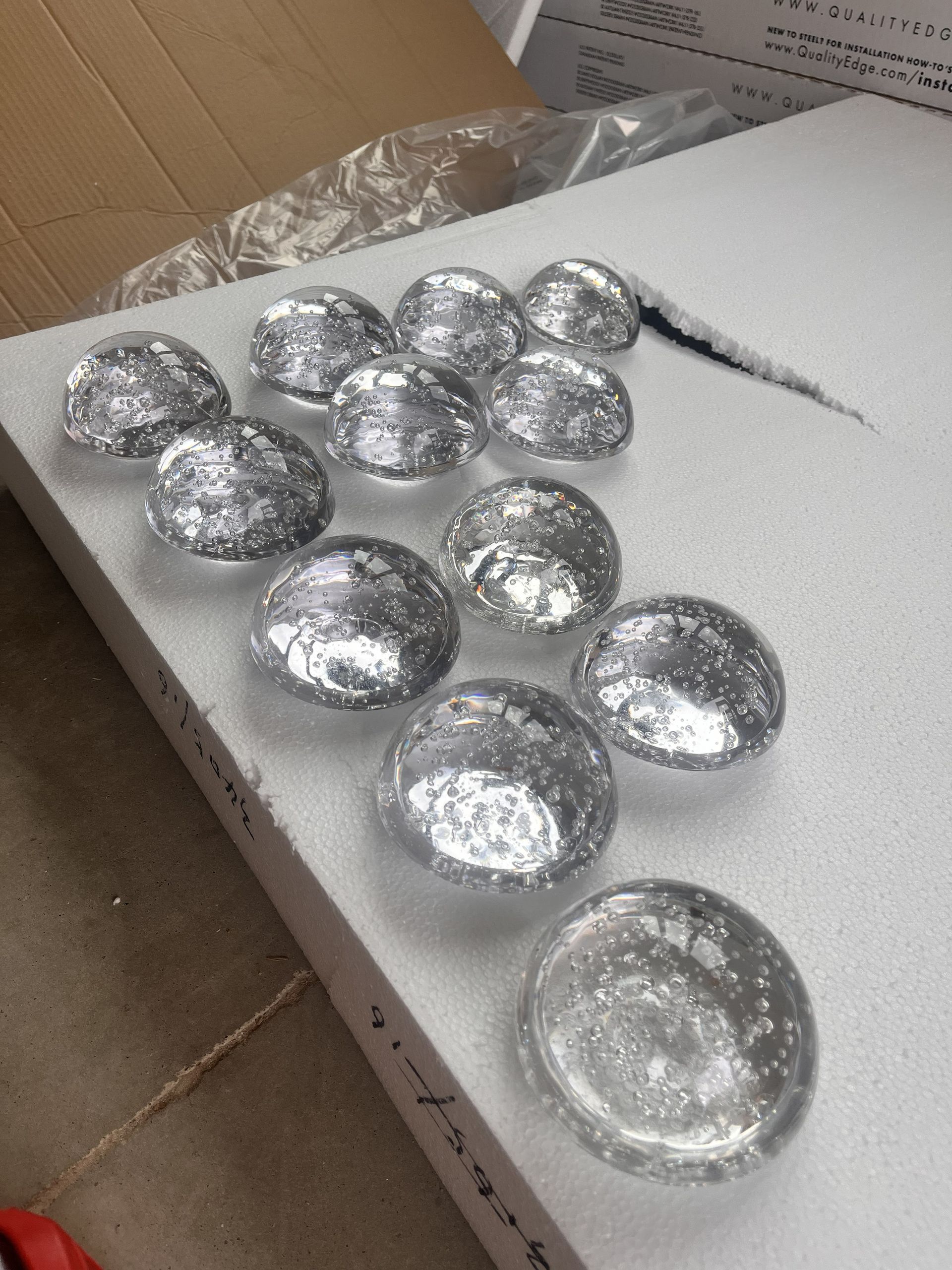 Silver foil-wrapped chocolates in a cardboard box on a white tray