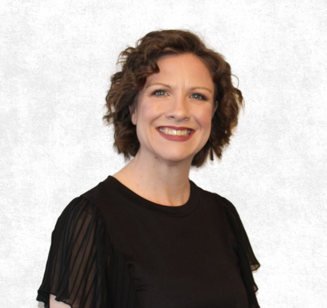 Smiling person in a black top against a light gray background