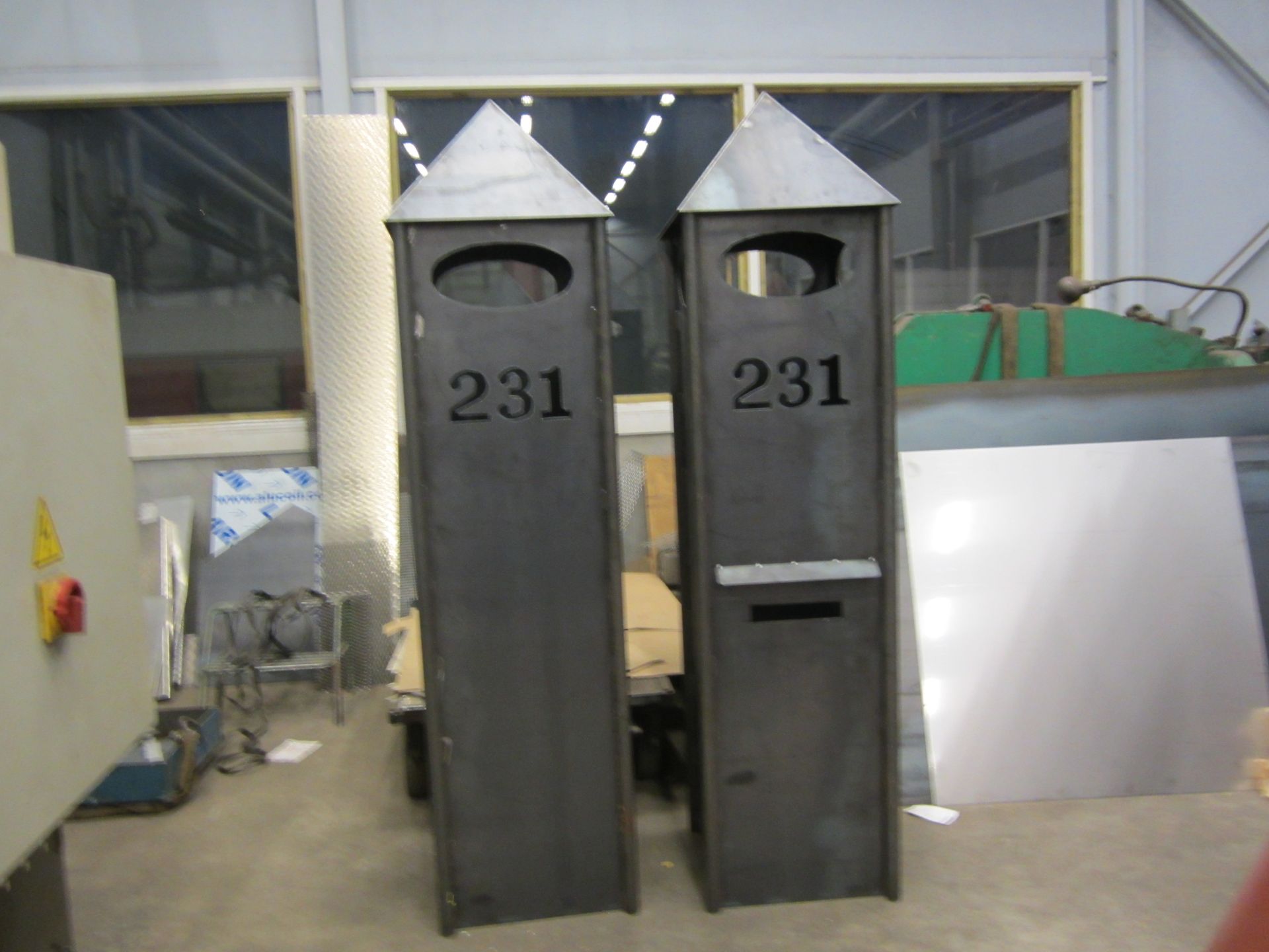 To mørke metallpostkasser, hver med spiss tak, ovalt vindu og nummeret 231.