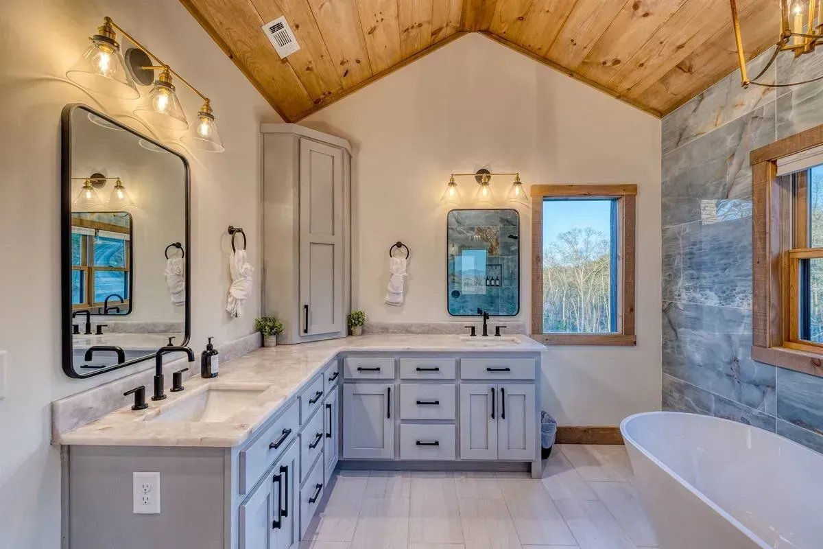 Bright bathroom with white double vanity, wood ceiling, black fixtures, mirrors, and a freestanding tub