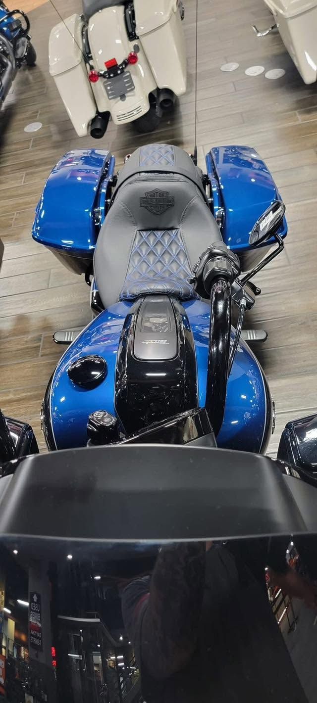 Blue and black wheelchair seated in a hallway, viewed from behind, with another chair ahead