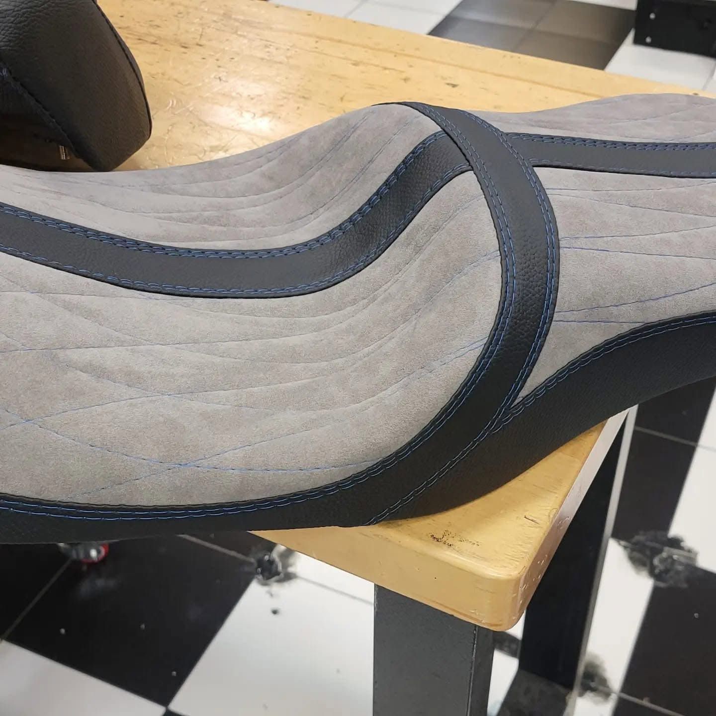 Gray and black shoe upper sample on a wooden table in a workshop setup
