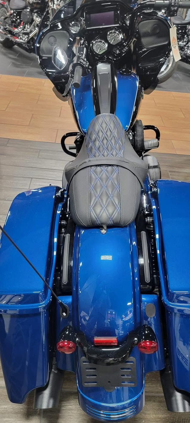 Blue touring motorcycle viewed from above, with black saddlebags and a gray seat cover.
