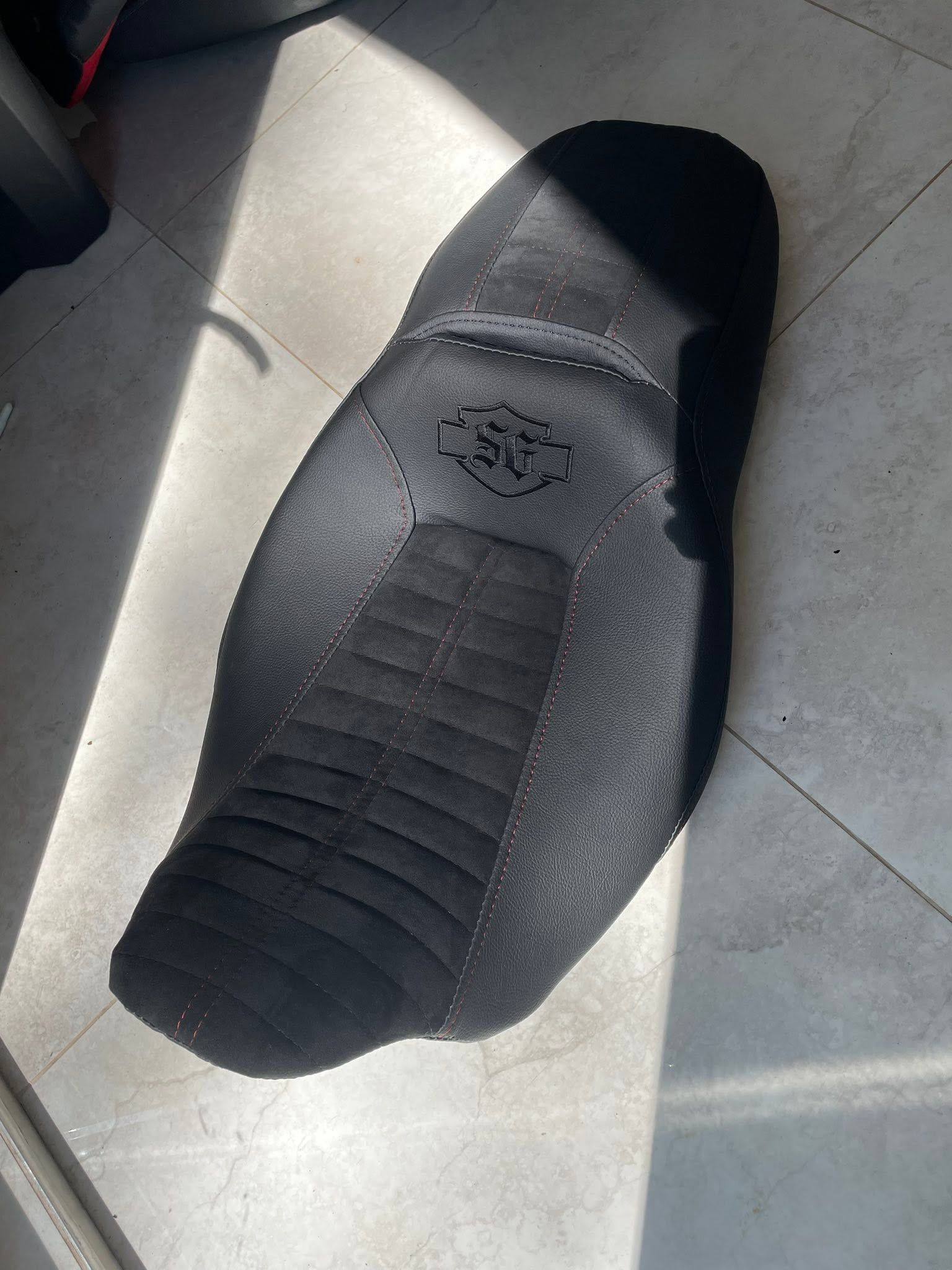 Black slip-on shoe sole on a light seat, shown close up in sunlight.