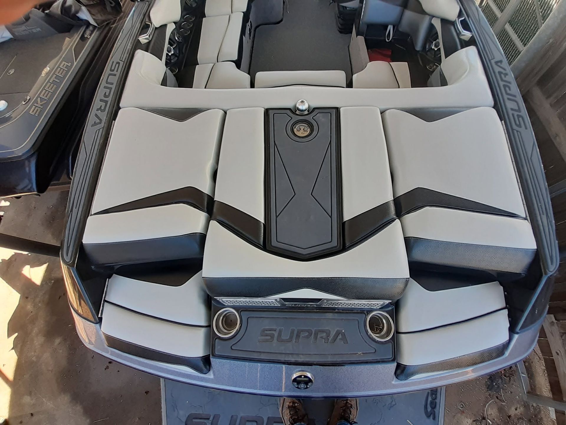 Close-up of a gray and black Supra boat engine cover with chrome accents and “SUPRA” badge.
