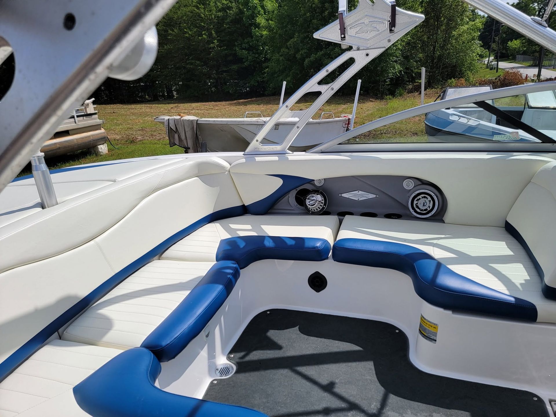 Blue-and-white boat seating area with a fold-out sun pad on the water.