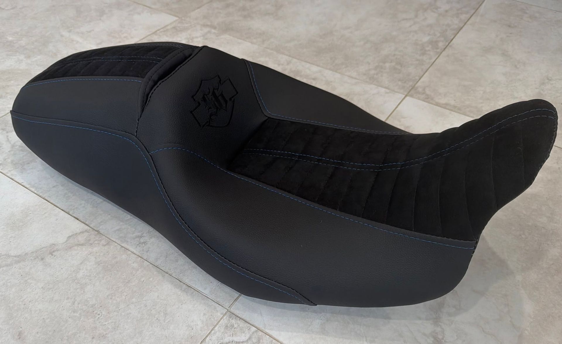Black inflatable wedge-shaped seat cushion on a tiled floor