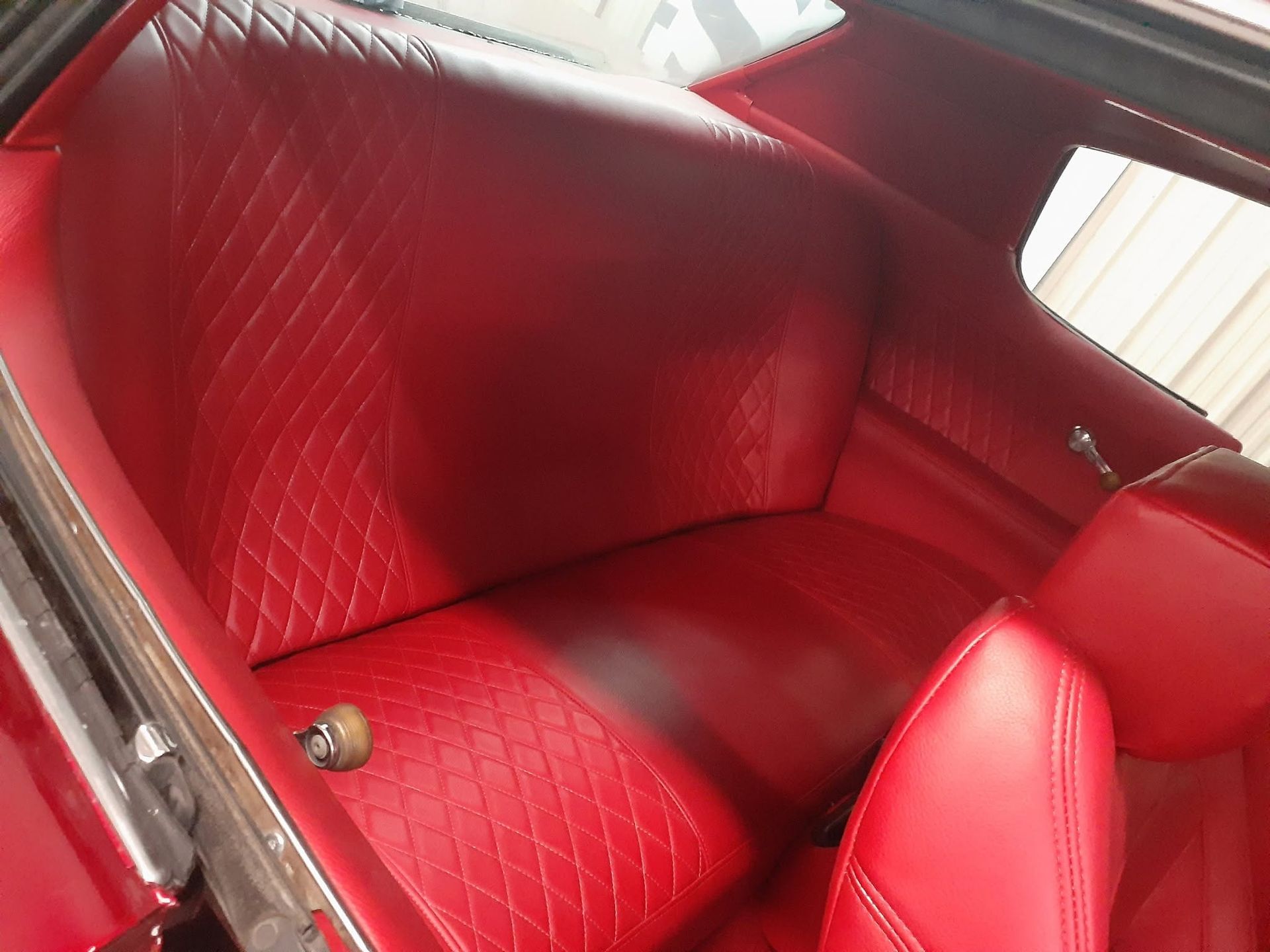 Brown and white vintage car interior with leather seats and wood steering wheel