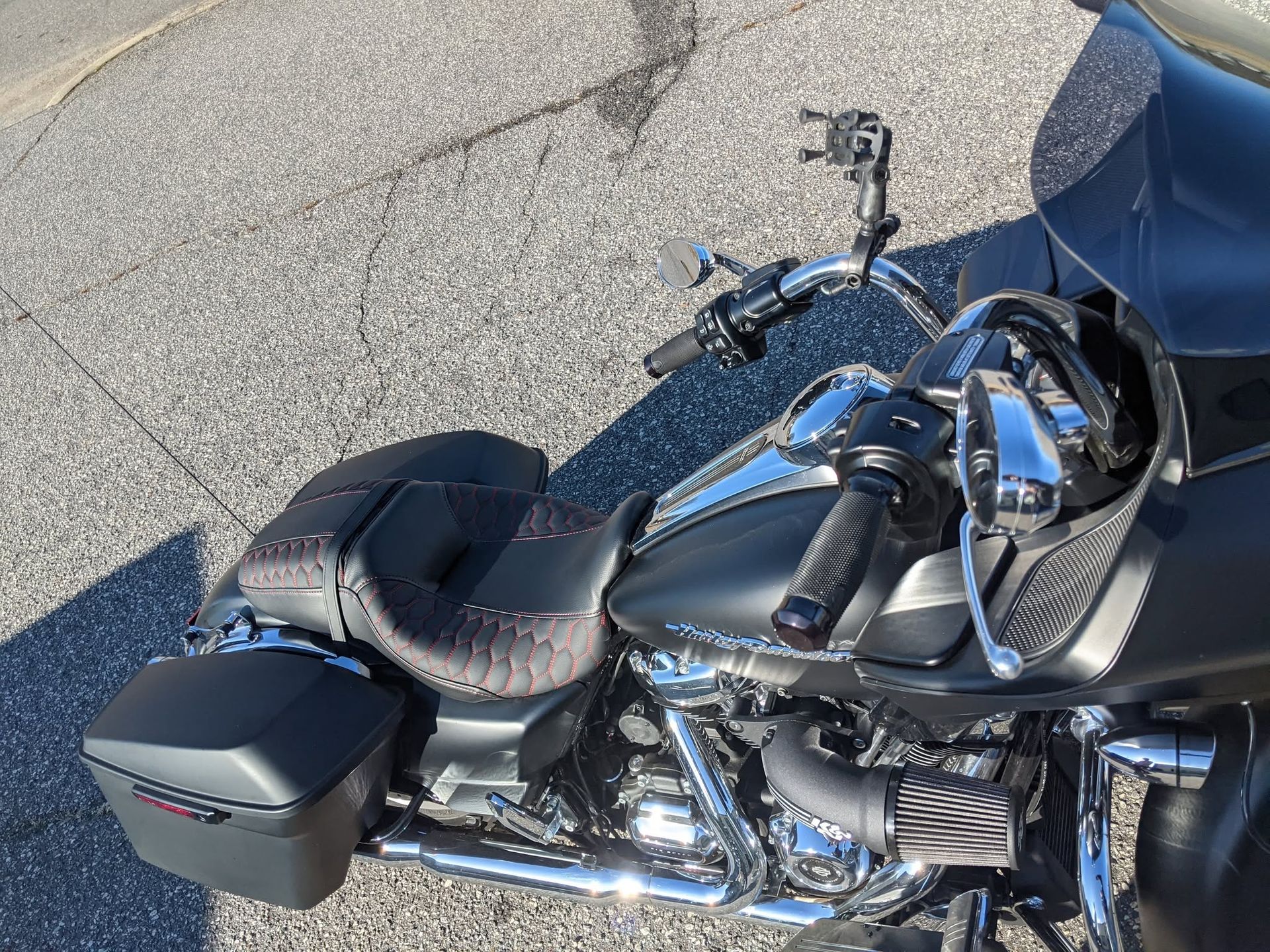 Black motorcycle parked on pavement, showing chrome engine and leather seat with saddlebag.