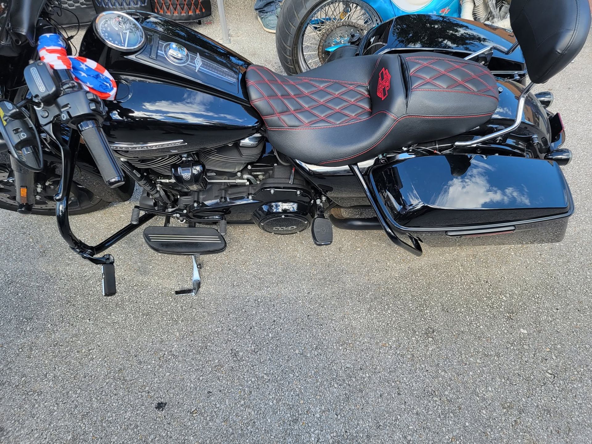 Black cruiser motorcycle with red accents parked on pavement, side view