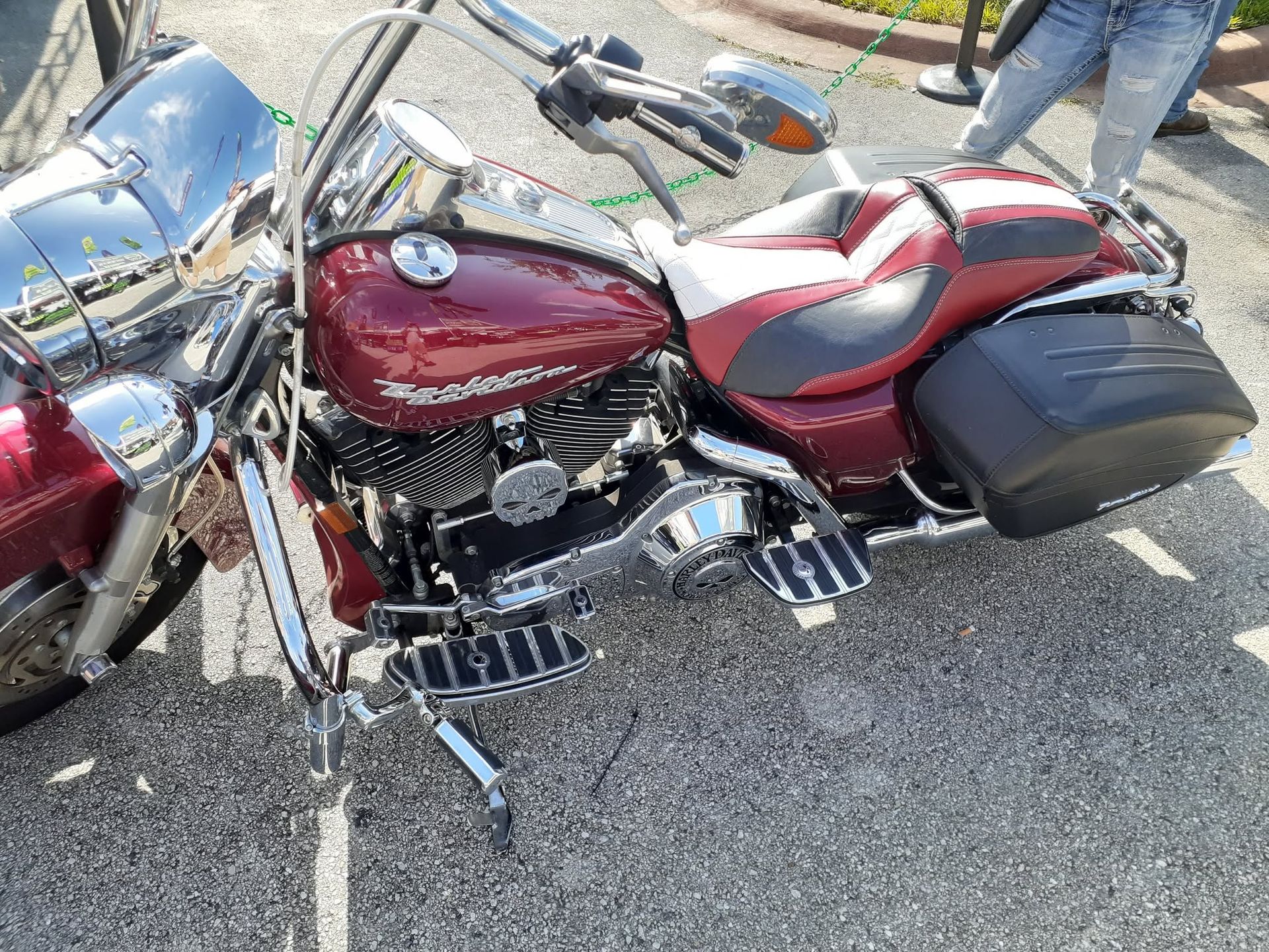 Red-and-silver motorcycle parked on asphalt with black saddlebags