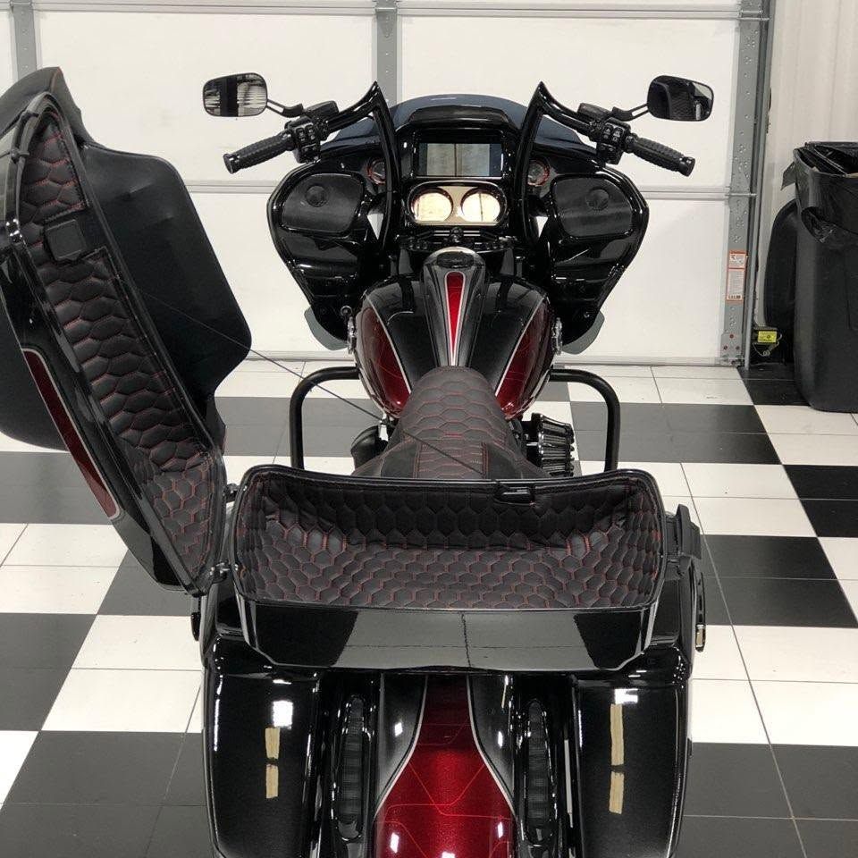 Black custom motorcycle with a red center panel, shown from the rear in a garage.