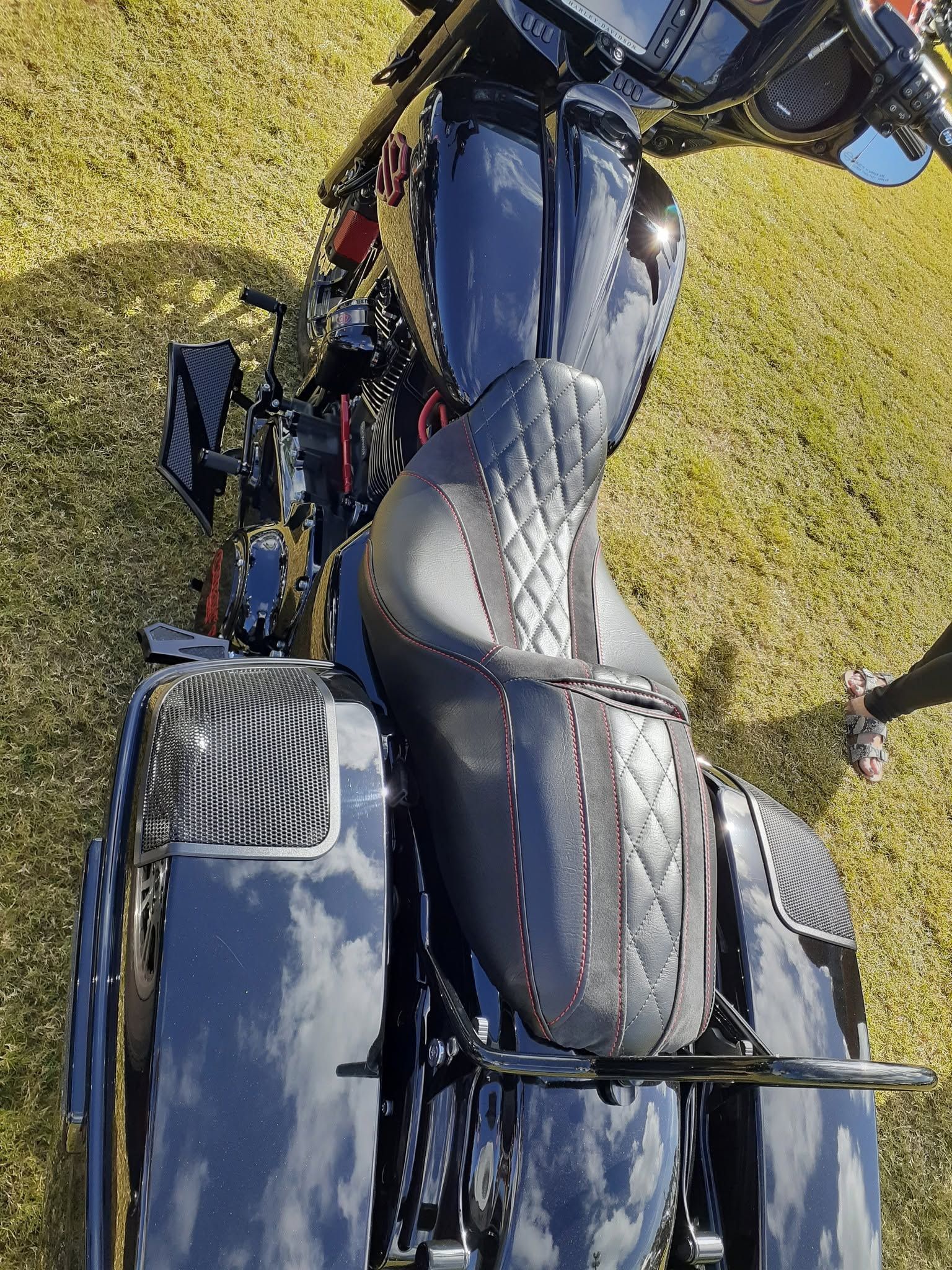 Overhead view of a black motorcycle parked on grass, showing the seat and handlebars