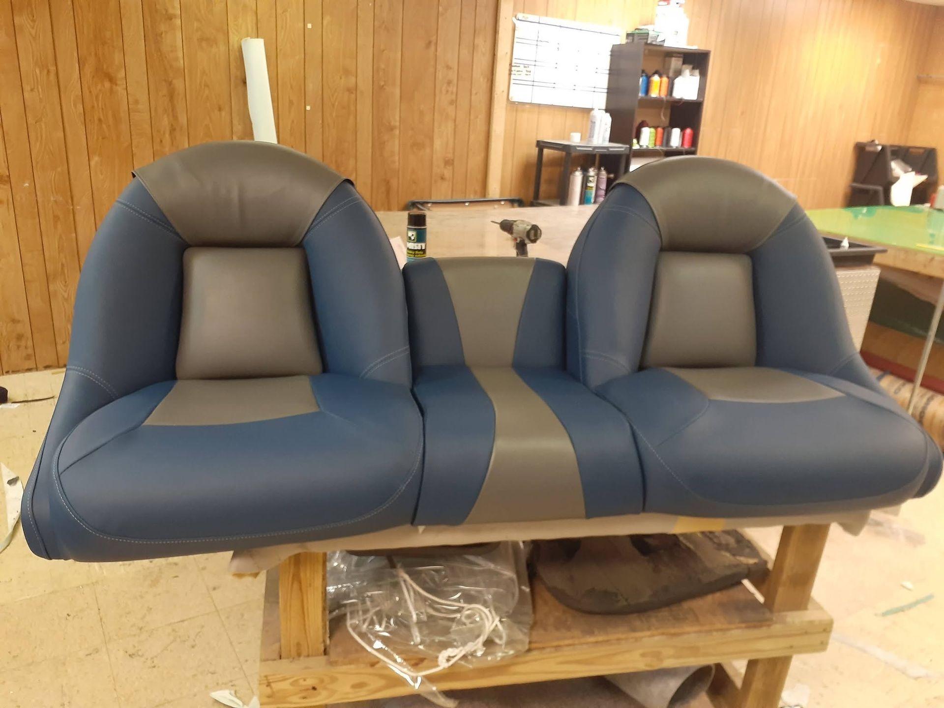 Blue-gray double reclining chair in a wood-paneled room.