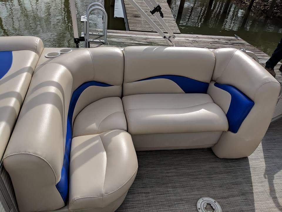 Padded gray boat captain’s chair beside the helm on a docked boat