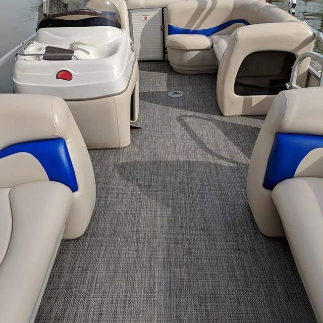 Leather yacht lounge with cream and blue seating around a central table on gray carpeted deck