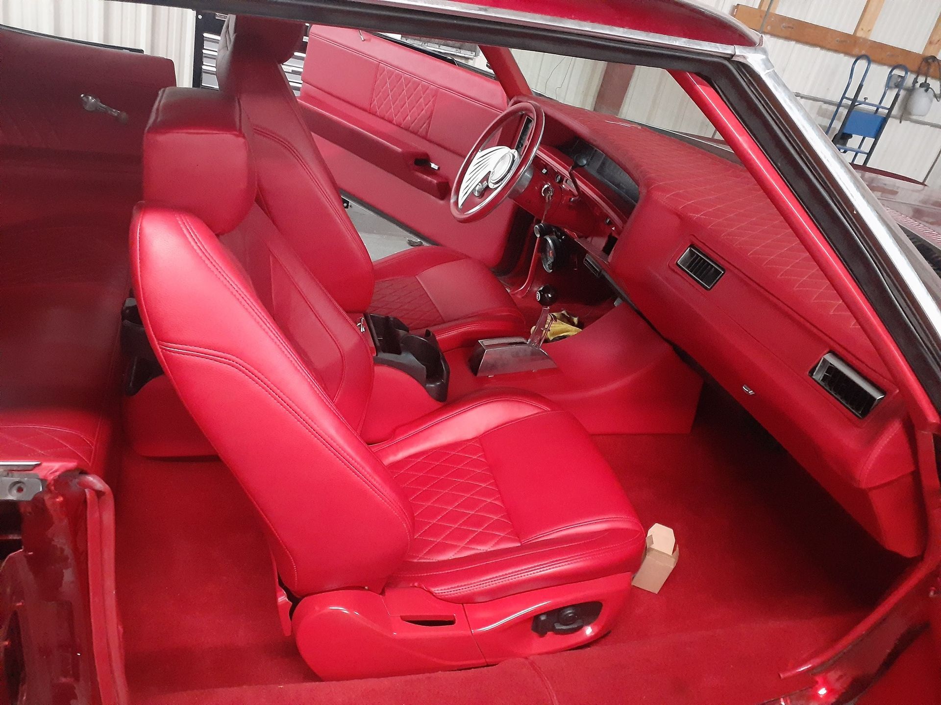 Red car interior with red leather seats and dashboard, viewed from the passenger side
