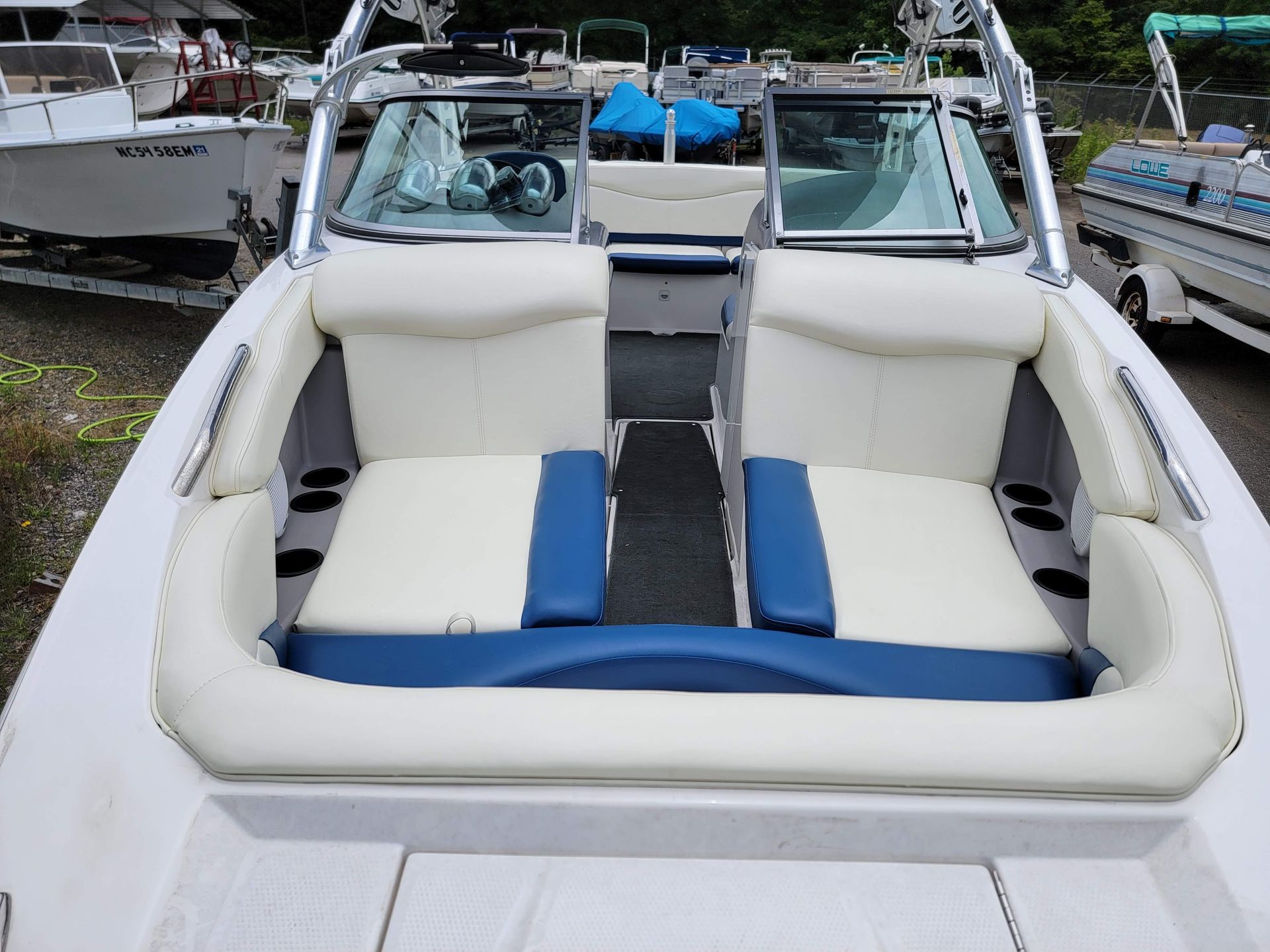 White and blue boat seating area on a docked speedboat, seen from the stern to the bow.