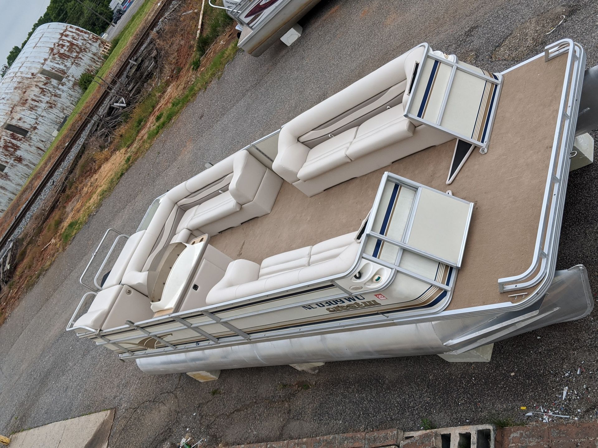White sectional sofa set displayed outdoors on pavement, arranged in a U-shape.