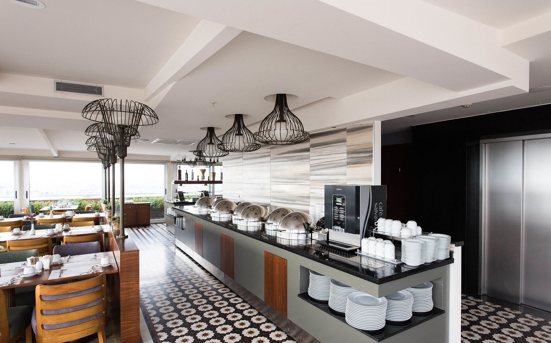 A restaurant with a long buffet line and tables and chairs.