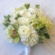 White and pale green floral bouquet with roses and hydrangeas tied with a white ribbon
