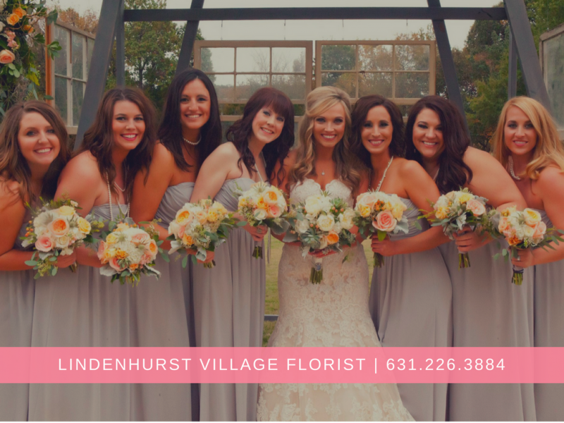 Bridal party holding pastel bouquets in front of a garden arch with Lindenhurst Village Florist text below