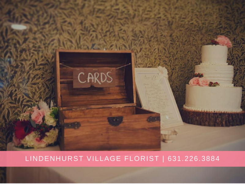 Card box and white tiered cake on a decorated table at Lindenhurst Village Florist