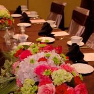 Floral centerpiece on a set dining table with plates, cups, and folded napkins