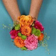 Hands holding a colorful bouquet of orange, pink, and green flowers on a blue background