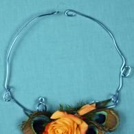 Silver wire bracelet with orange rose accents on a blue background