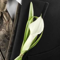 White calla lily boutonniere pinned to a black suit lapel