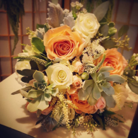 Orange and white rose bouquet with greenery in a decorative arrangement