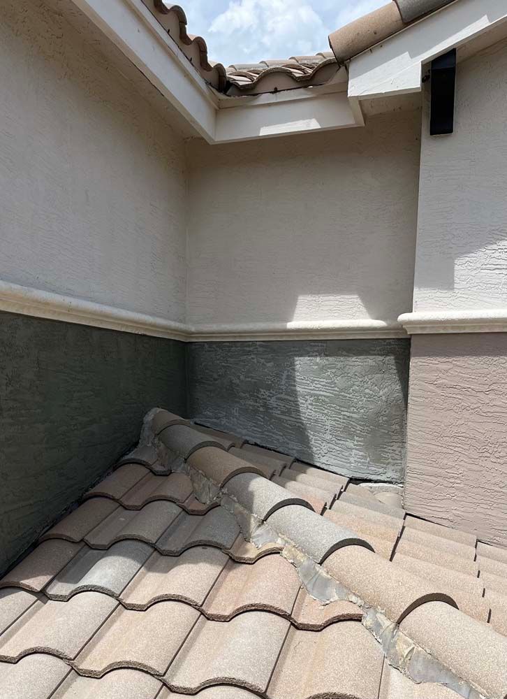 A roof with a lot of tiles on it and a corner of a building.
