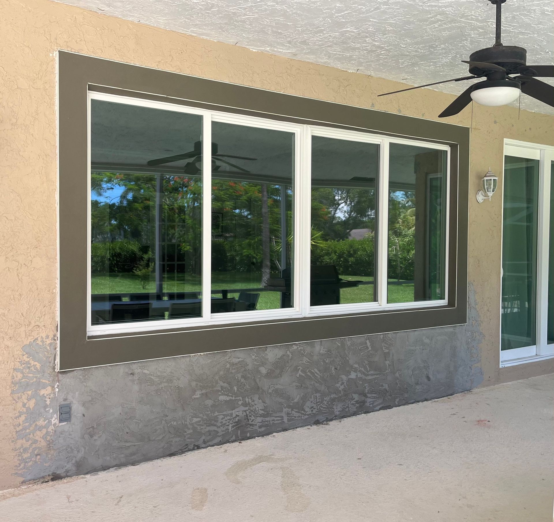 A large window with a ceiling fan above it
