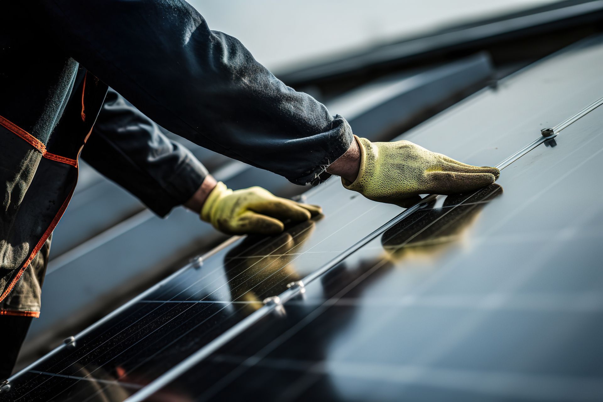 Eine Person in Arbeitshandschuhen installiert Solarpaneele auf einem Dach.