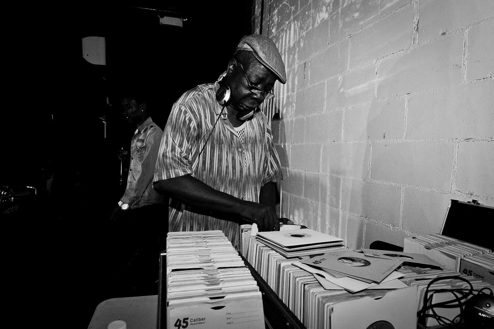 A black and white photo of a man looking at records