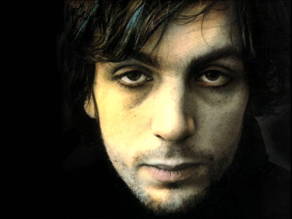 A close up of a man 's face with a black background.