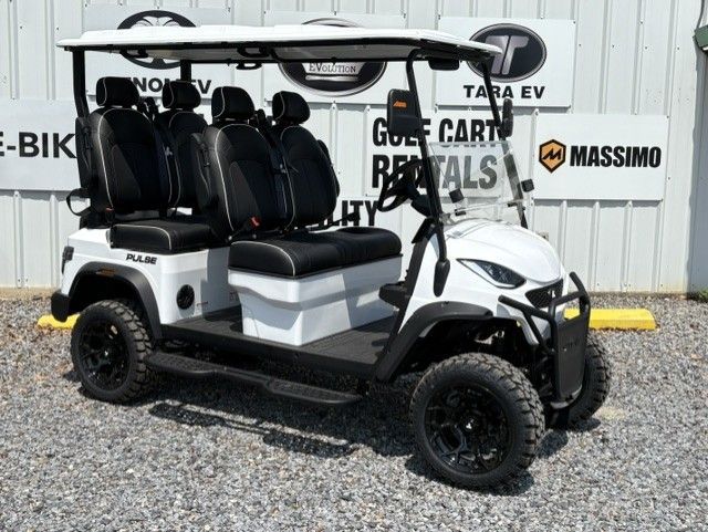White golf cart with black seats parked on gravel in front of a building.