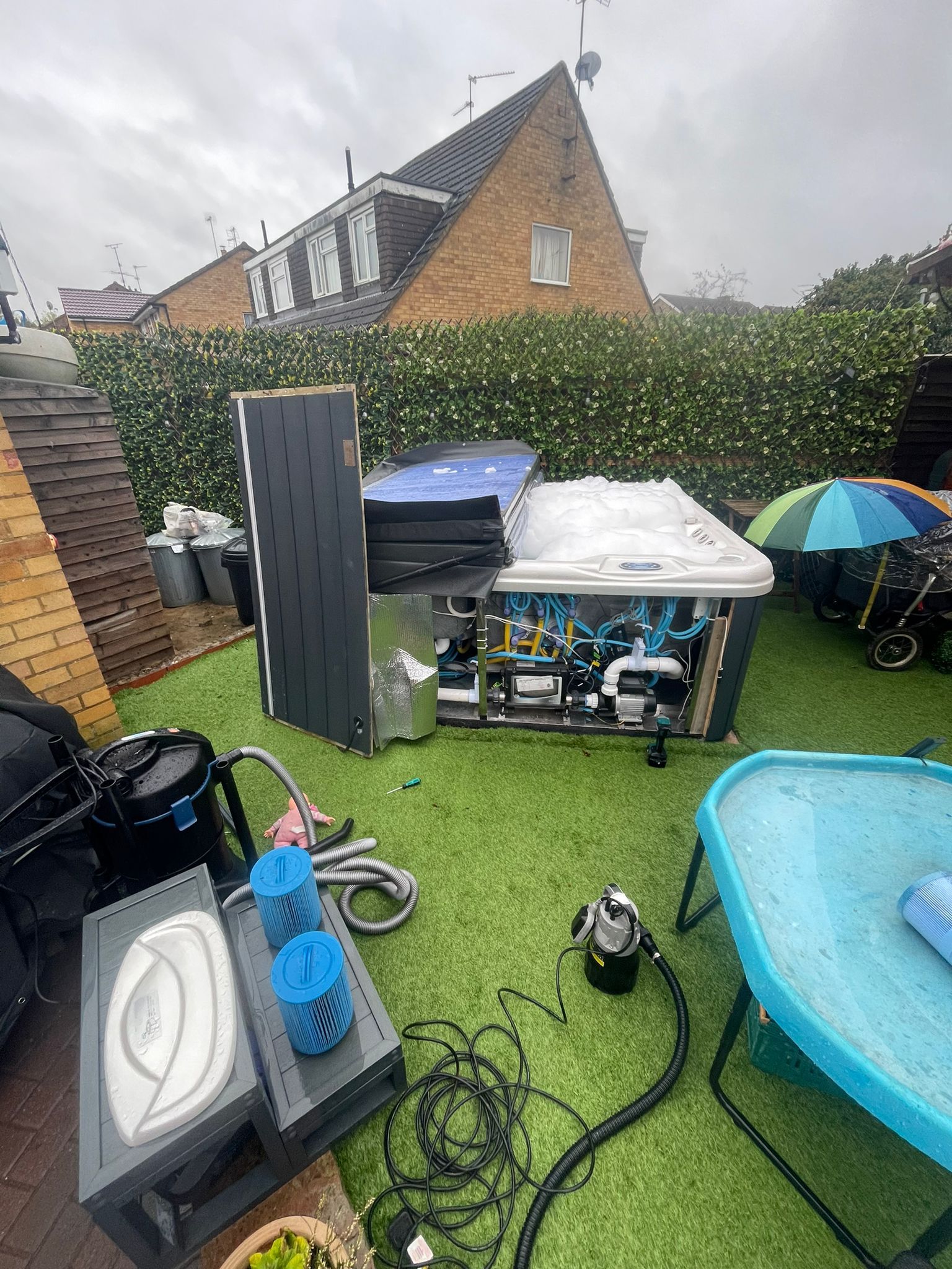 A hot tub is sitting on top of a lush green lawn in a backyard.