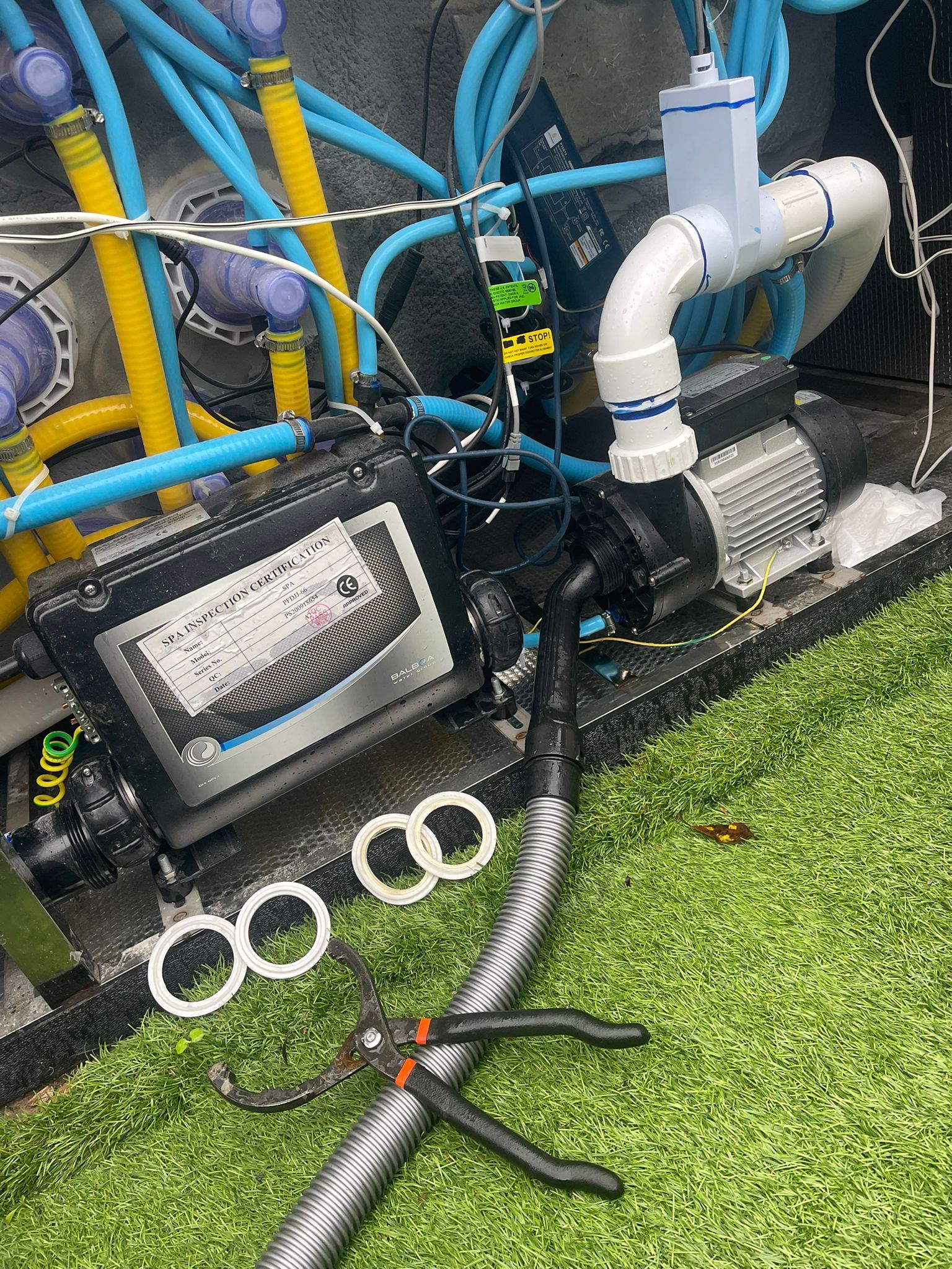 A hose is laying on the ground next to a machine.